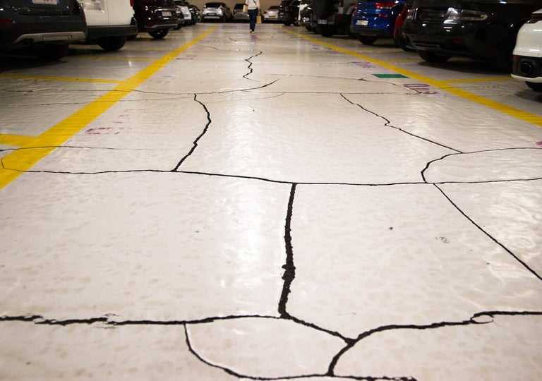 Cracked and worn concrete garage floor surface showing damage that signals it is time for a new coated floor