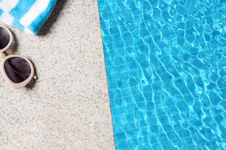 Edge of pool with beach towel and blue pool water texture