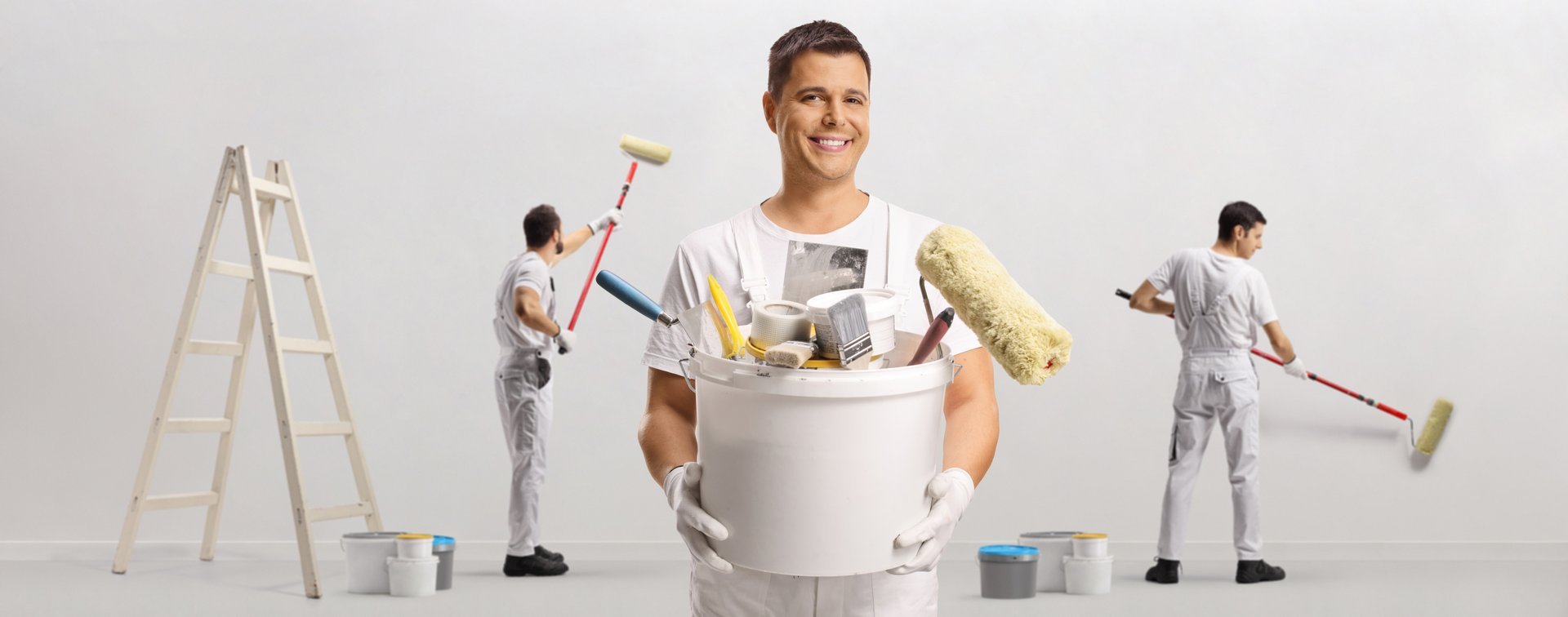 Team of painters with tools and brushes painting a wall