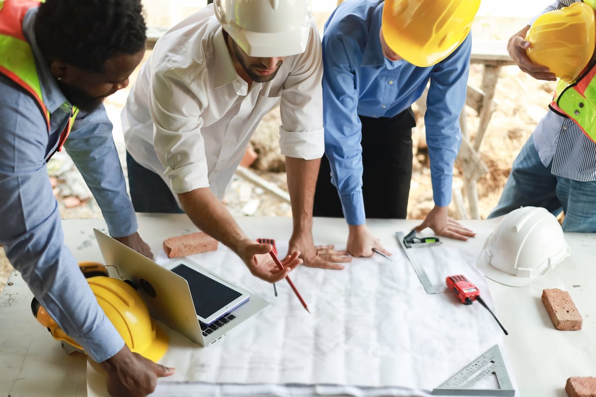 Group of engineers and staff discussing progress at residential construction site