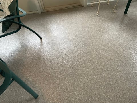 Clean beige carpet in a room with dark chairs and furniture legs visible